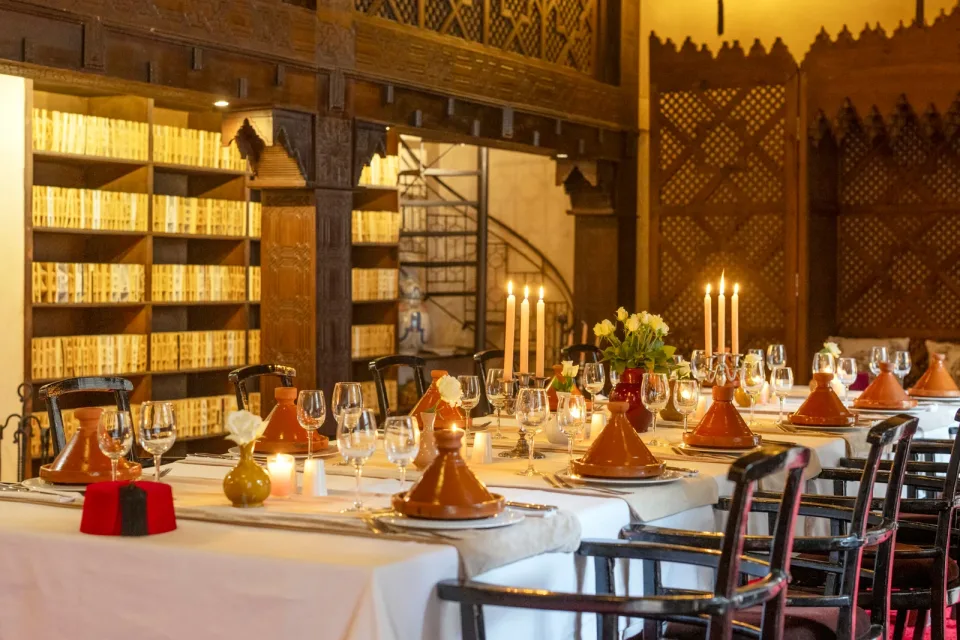 Elegant Moroccan dining table with tajines and candles at Almaha Marrakech restaurant in the Kasbah Elegant Moroccan dining table with tajines and candles at Almaha Marrakech restaurant in the Kasbah